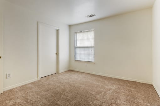 a bedroom with white walls and carpet