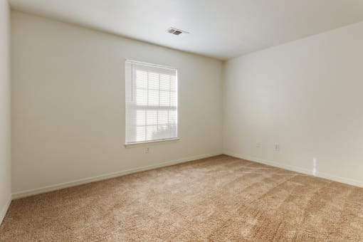 a bedroom with white walls and a window