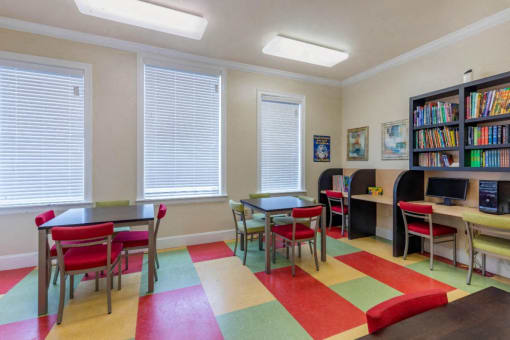 Activity Center with color floor mats, shelves, with books, and computers
