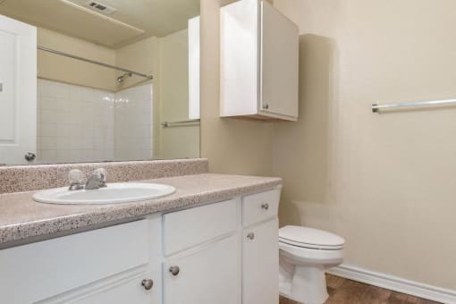 Bathroom with white cabinets and extra storage above the toilet