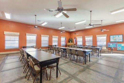 Clubhouse meeting room with tables, chairs, and orange walls