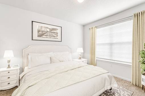 Bedroom with large window and a queen size bed with night stands
