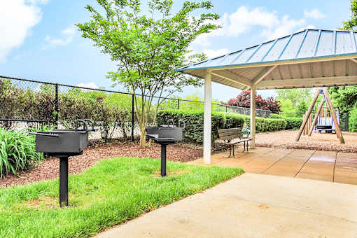 A playground with a swing set and a green tree.