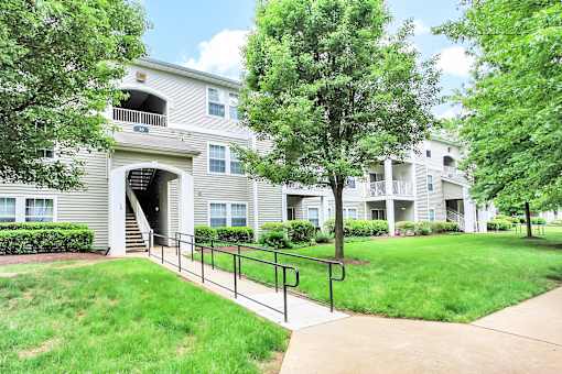 Apartment complex with a walkway in front.