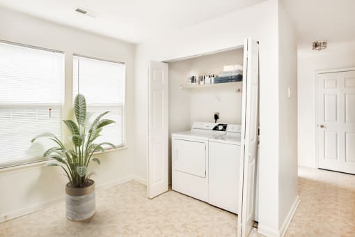Virtually staged Laundry room with large windows and tile floor.