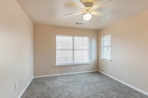 Bedroom with wall to wall carpet, ceiling fan, and windows