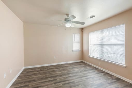Living room with ceiling fan and windows and blinds