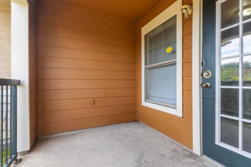 Balcony with window, tan walls, and blue door