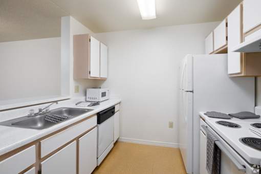 A kitchen with white appliances and cabinets.