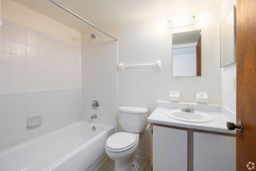 A white bathroom with a toilet, sink, and bathtub.