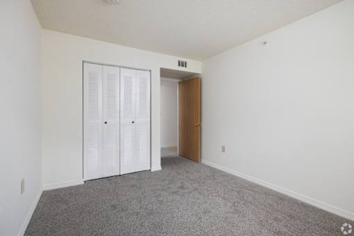 A room with a white wall and a brown door.