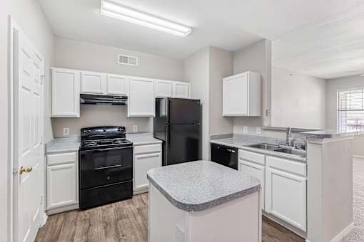 A kitchen with black appliances and white cabinets.