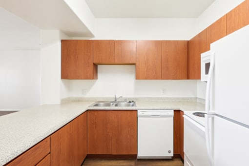 a kitchen with white appliances and wooden cabinets