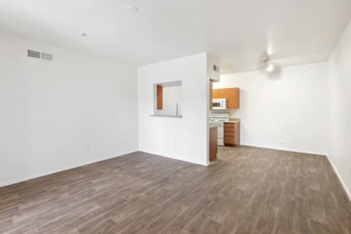 the living room and kitchen of an empty apartment
