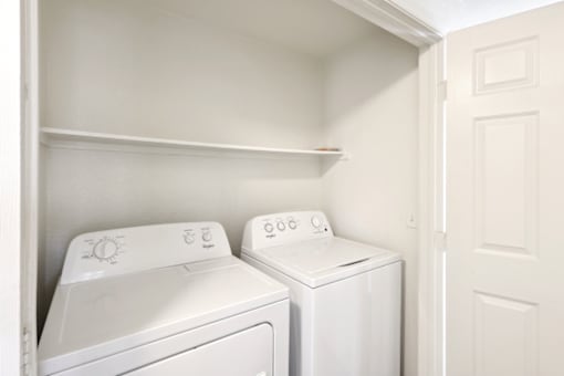 an empty laundry room with a washer and dryer
