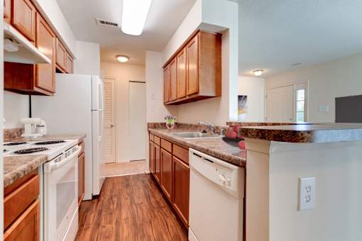 a kitchen with white appliances and wooden cabinets
