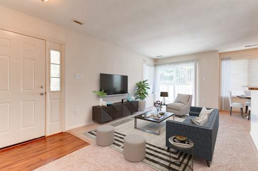 a living room with white walls and a sliding glass door