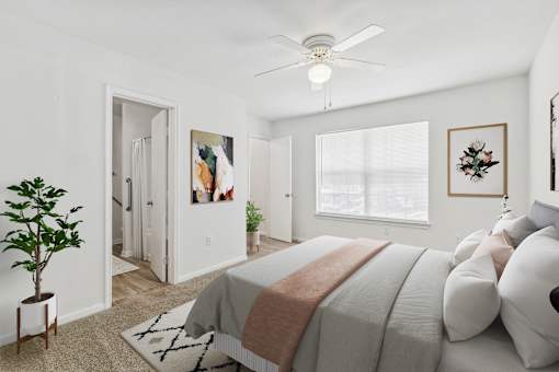 A bedroom with a large bed and a ceiling fan.