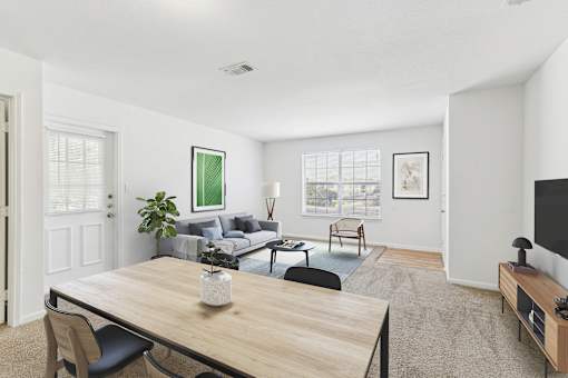 A living room with a couch, a chair, a coffee table, and a television.