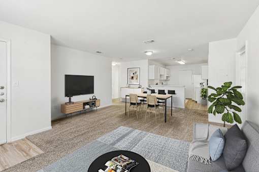 A living room with a grey couch, a black coffee table, and a white wall.