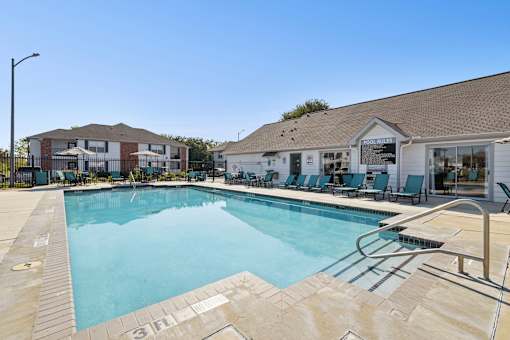 A large swimming pool with a slide and lounge chairs.
