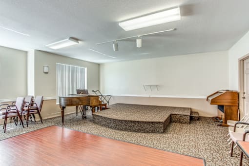 an empty living room with a piano and a dance floor