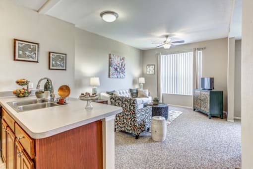 a living room with a couch and a kitchen with a sink