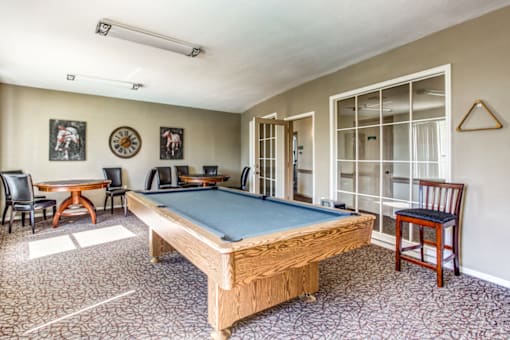 a game room with a pool table and chairs
