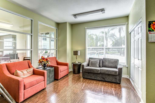 a living room with a couch and chairs and a window
