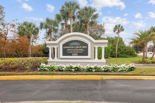 an image of the entrance of a park with flowers