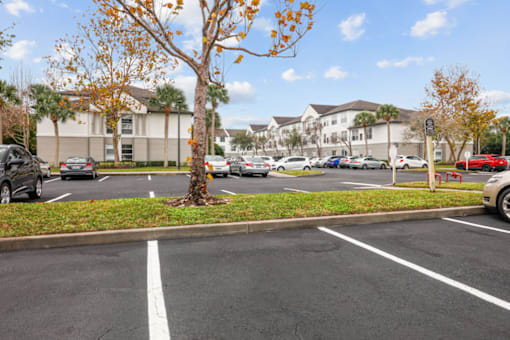 a parking lot with cars in front of apartment buildings
