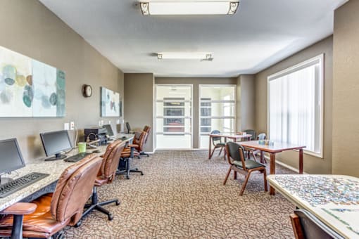 a conference room with desks and chairs and a large window