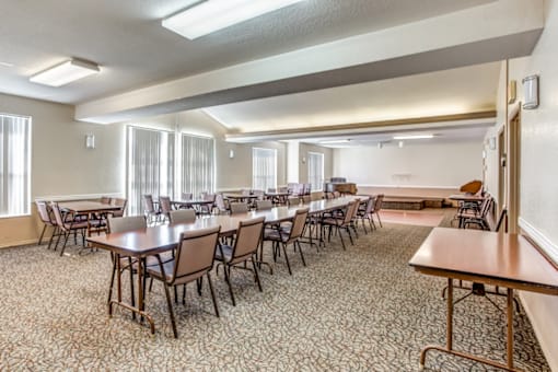a conference room with tables and chairs and a projection screen