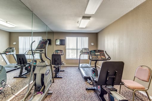 a gym with weights and cardio equipment in a room