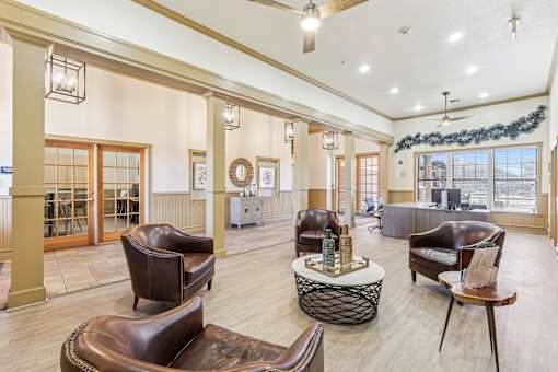A large room with leather chairs and a table with a bottle on it.