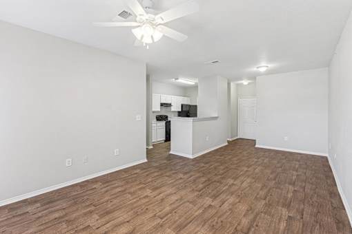 A room with a ceiling fan and wooden flooring.
