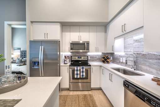 a kitchen with white cabinets and stainless steel appliances