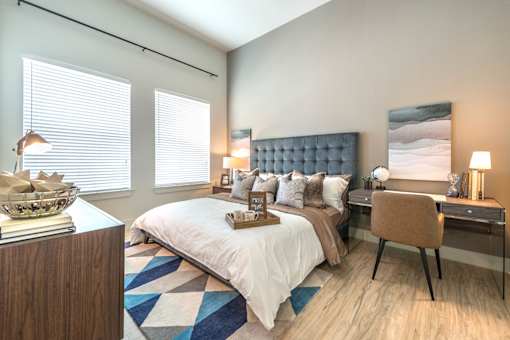 a bedroom with a large bed and a desk with a chair