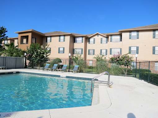 A swimming pool in front of apartment buildings.