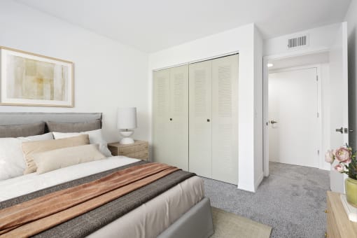 a bedroom with a large bed and two closets