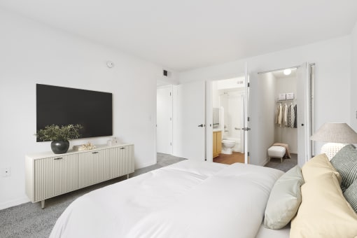 a bedroom with a large bed and a tv on the wall