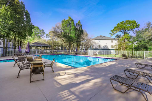 a swimming pool with chaise lounge chairs and a gazebo