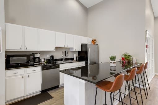 a kitchen with white cabinetry and black countertops