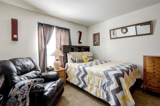 Model Bedroom with Large Window Recliner Bed Night Stand and Chest of Drawers