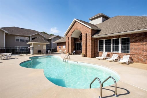 Leasing Office Exterior with Swimming Pool and Sun Deck with Lounge Chairs and Building Exterior in the Background