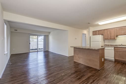 a kitchen and living room with a sliding glass door leading to a balcony