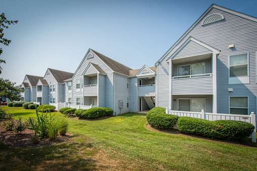 A row of houses with green lawns in front.