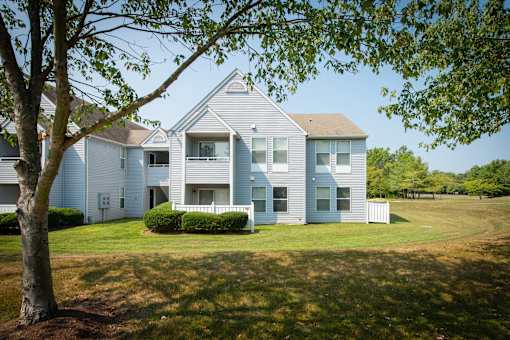 A large house with a white picket fence in front.