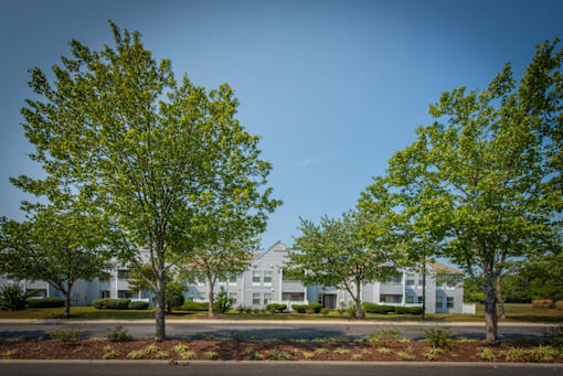 a picture of a street with apartment buildings in the background