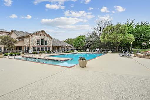 A large outdoor swimming pool with a building in the background.